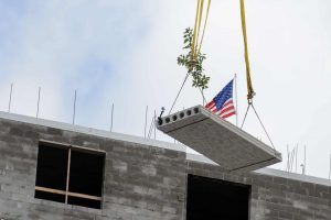 A flag and oak tree are lifted to the roof during topping off ceremony for the STEM residence hall on Sept. 14, 2015. (Peter Morenus/UConn Photo)