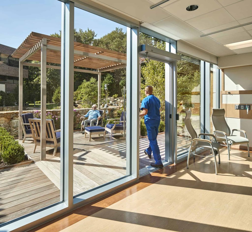 Shepley Bulfinch designed the infusion Bays to be strategically located on the Garden Façade of the Park Avenue Medical Center, allowing us to create private outdoor spaces where the patients could escape from the hospital setting and receive infusion in a natural outdoor environment/Robert Benson Photography Exterior: “A large canopy at the Park Avenue Medical Center welcomes patients and visitors while protecting from the elements.” Shepley Bulfinch Completes 100,000 SF Outpatient Center for Yale New Haven Health Park Avenue Medical Center offers private infusion suites overlooking healing garden with waterfall 