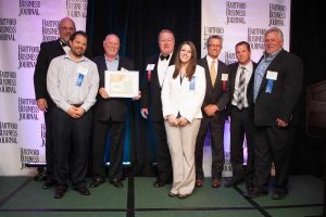 United Steel’s president, Ken Corneau (holding plaque), accepts the 2015 Family Business Award from the Hartford Business Journal at an October 14 gala event. Corneau is joined by members of the Hartford Business Journal as well as members of his family who work at the company. The company, which is based in East Hartford, is New England’s largest fabricator and erector of structural steel and miscellaneous metals.