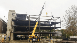 Members of the construction team raise the final beam into place